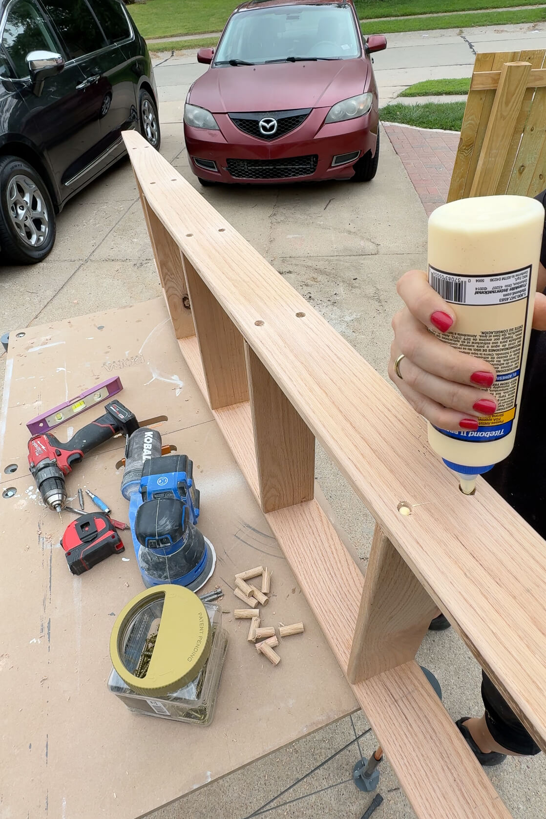 Adding dowels to cover screw holes on a ladder for DIY bunk beds.